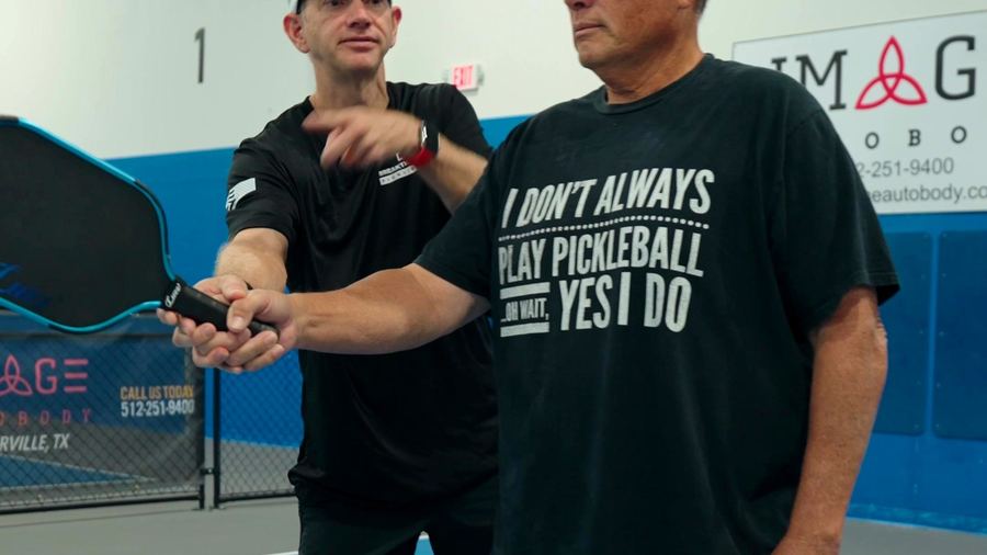 Coach correcting a player’s grip on court