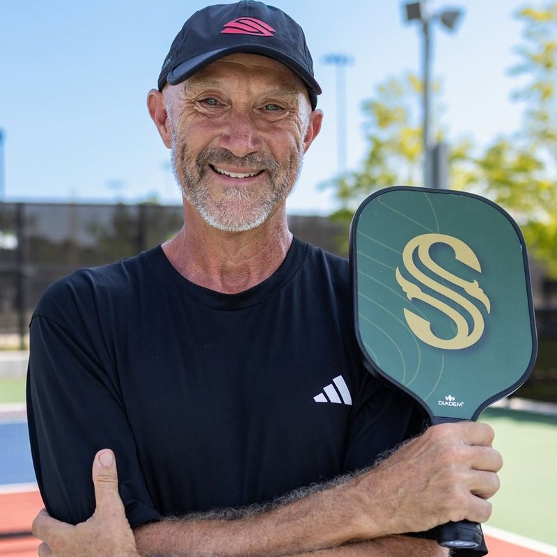 Coach Shawn Smith holding a Diadem paddle on an outdoor court